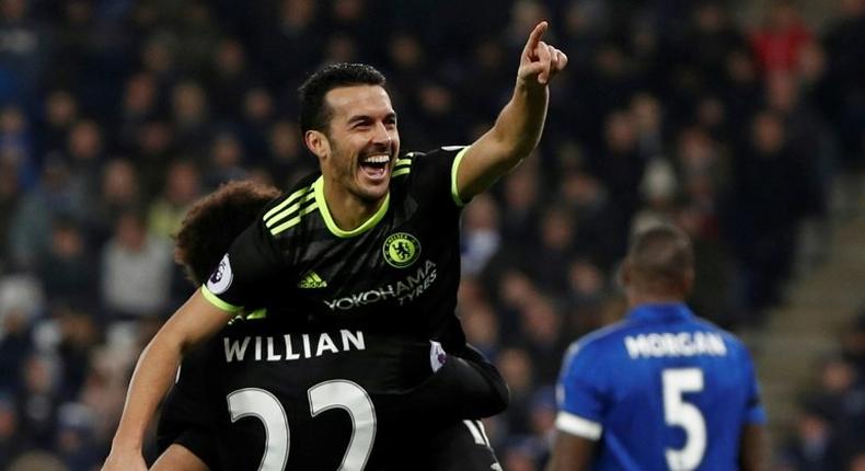 Chelsea's midfielder Pedro celebrates in the arms of midfielder Willian after scoring their third goal during the English Premier League football match between Leicester City and Chelsea on January 14, 2017