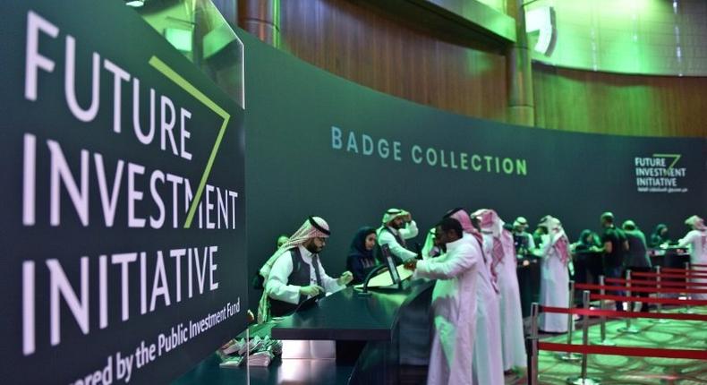 Saudi journalists collect their press badges for the Future Investment Initiative -- a key gathering overshadowed by the killing of critic Jamal Khashoggi