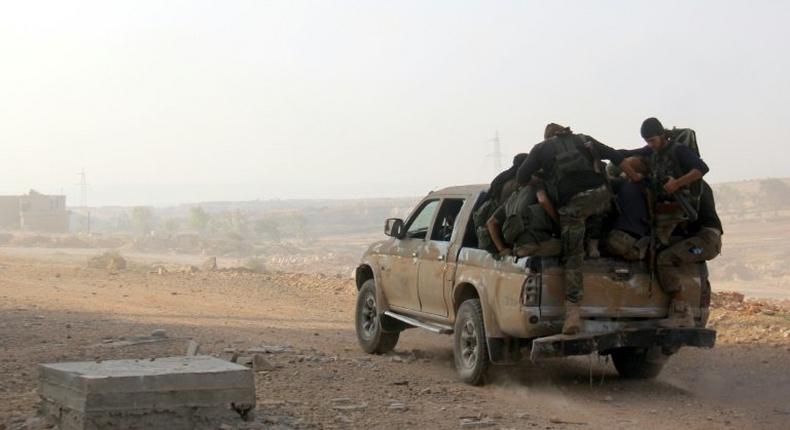 Fighters from Fateh al-Sham Front advance on a road south of Aleppo on August 6, 2016