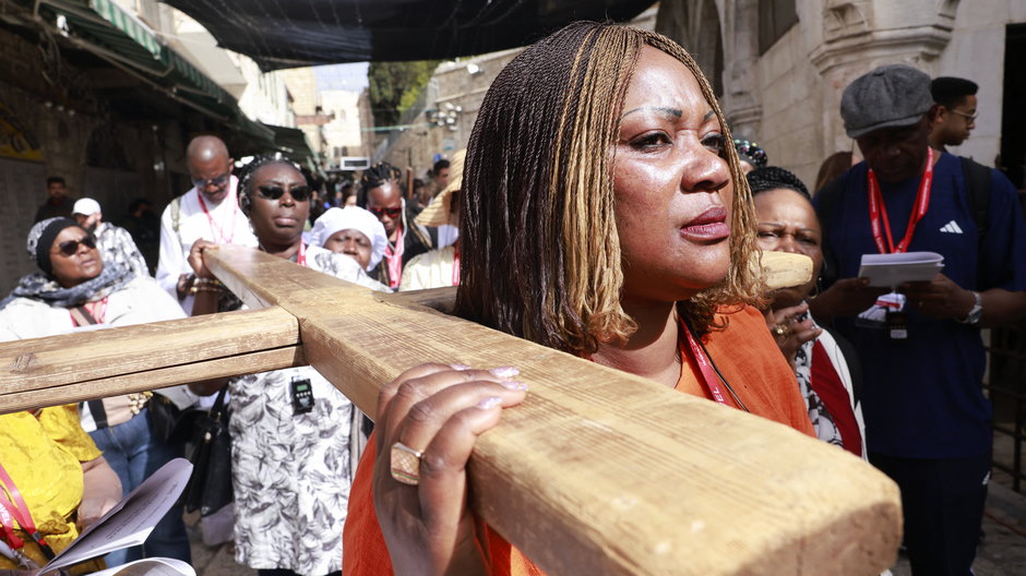 Pielgrzymi niosą drewniany krzyż wzdłuż Via Dolorosa (Drogi Cierpienia) na Starym Mieście w Jerozolimie podczas katolickiej procesji wielkopiątkowej 7 kwietnia 2023 r.