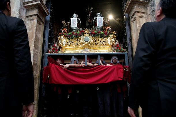 Costaleros leave a church as they take part in a procession during the Holy Week in Ronda