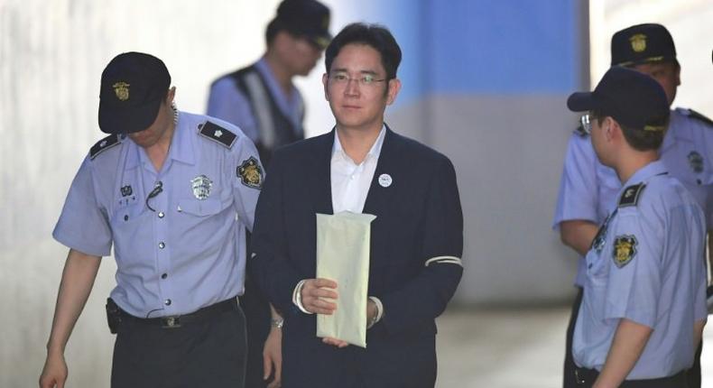 Lee Jae-Yong, the vice-chairman of Samsung Electronics, is escorted by prison guards as he arrives in court