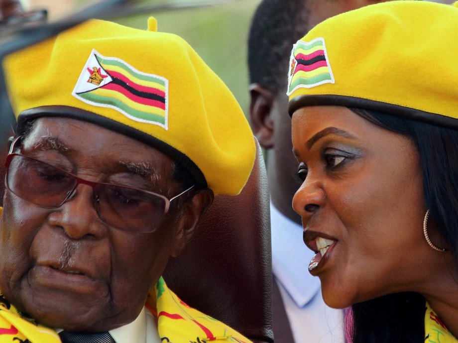 President Robert Mugabe listens to his wife Grace Mugabe at a rally of his ruling ZANU-PF party in Harare, Zimbabwe, November 8, 2017