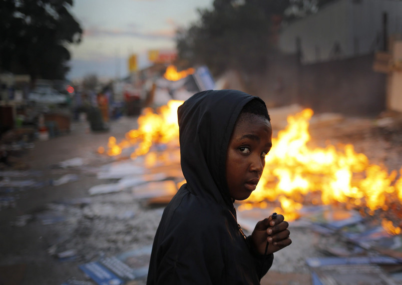 Mały mieszkaniec Johannesburga wśród ognisk, przy których ogrzewają się pozbawione schronienia rodziny; 5 czerwca 2014 roku...