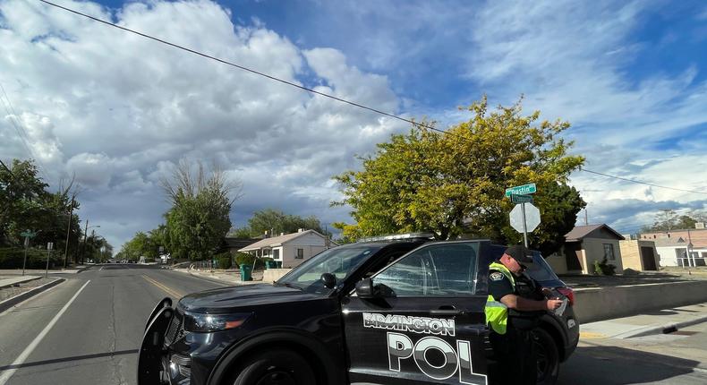 A police officer blocks traffic on a road following a deadly shooting Monday, May 15, 2023, in Farmington, New Mexico. Authorities said an 18-year-old opened fire in the northwestern New Mexico community, killing multiple people and injuring others, before law enforcement fatally shot the suspect.AP Photo/Susan Montoya Bryan