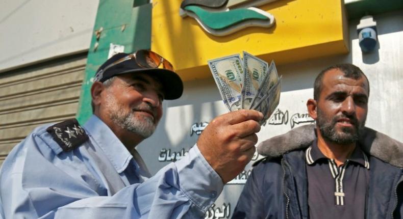 A Palestinian man shows his money after receiving his salary in Rafah in the southern Gaza Strip November 9, 2018