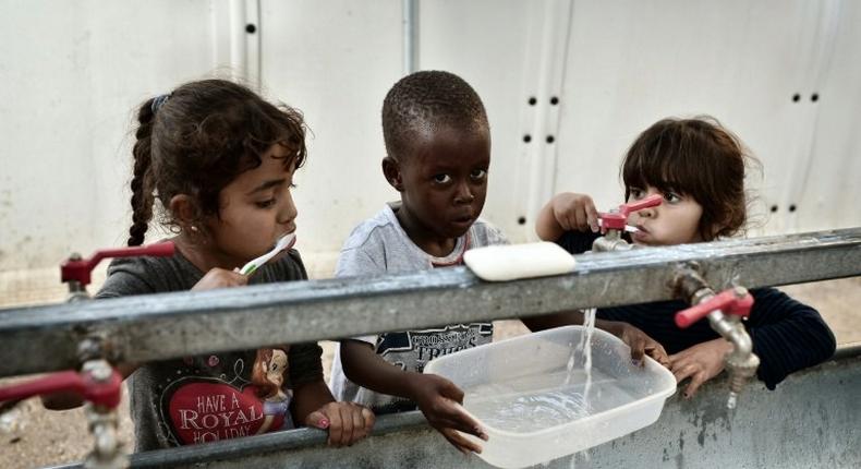 Children brush their teeth at the Souda municipality-run refugee camp on the Greek island of Chios on October 13, 2016