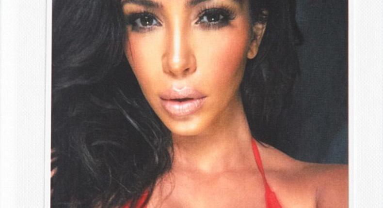 Kim Kardashain spotting a red bikini on the hard cover of the book, Selfish 