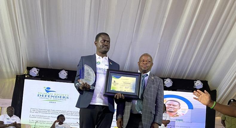 Ssentogo posing with his award. Besides him is the Iganga District Resident Judge, Justice David Batema