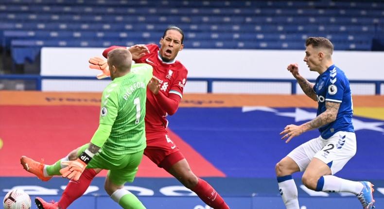 Everton goalkeeper Jordan Pickford tackles Liverpool defender Virgil van Dijk