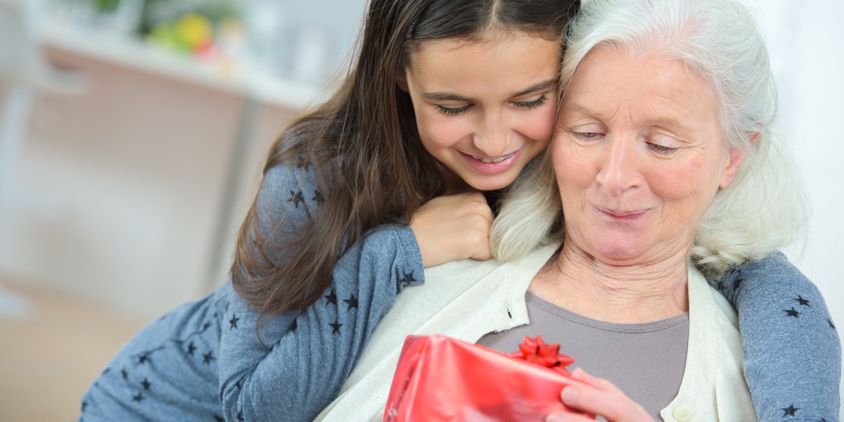 Happy mother's day! adult daughter gives flowers and congratulates an elderly mother on holiday 