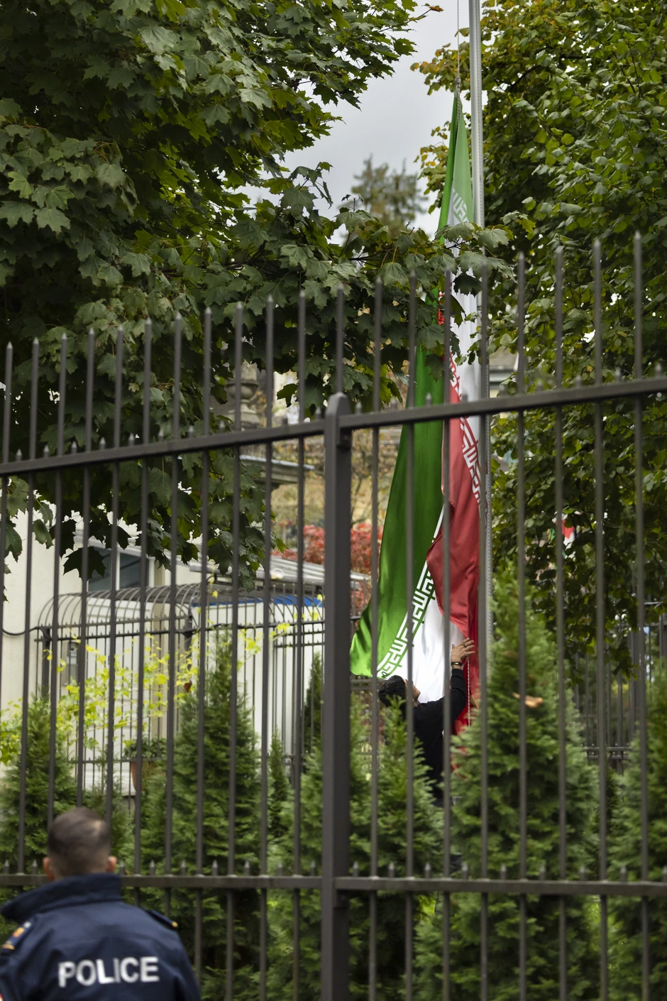 Protest ispred iranske ambasade u Bernu zbog smrti Mahse Amini - demonstrant skida zastavu