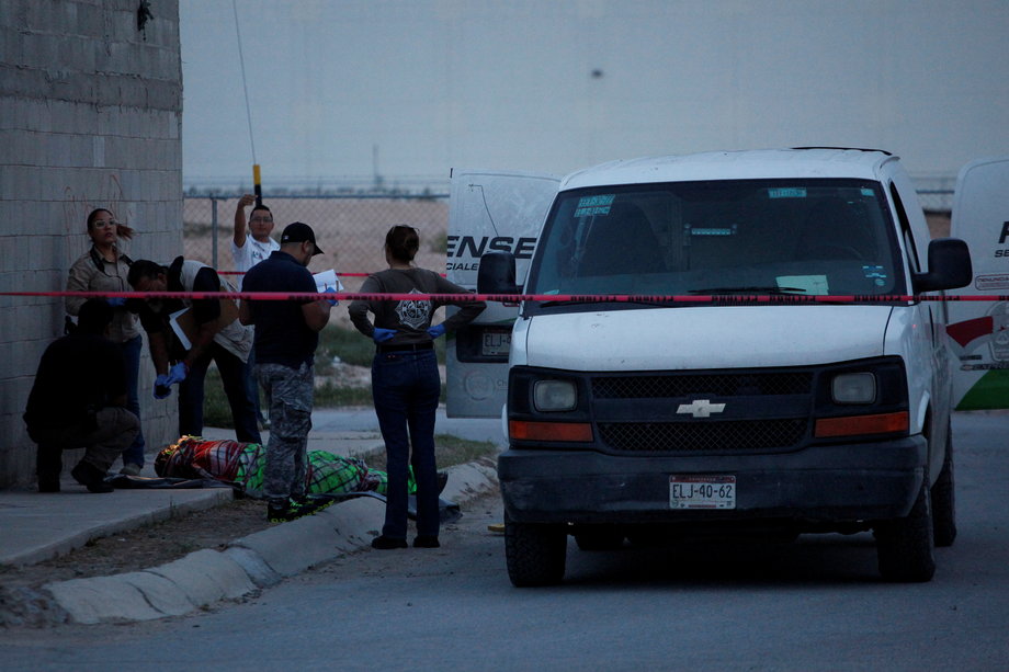 A forensic team works at the crime scene where a body was found wrapped in a blanket in Ciudad Juarez, Mexico, September 11, 2016.