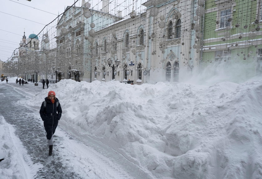 Workers remove snow in a street in Moscow