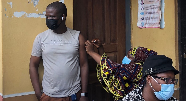 The author, Paul Adepoju (left), got his first Covid vaccine shot in Nigeria. The center was so crowded that there was no room to sit down.
