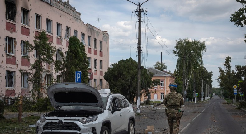 A Ukrainian soldier walks past a car in Sudzha, in Russia's Kursk region, in August 2024.AP Photo