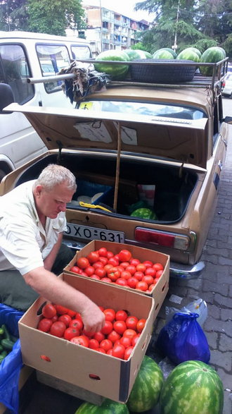 Pan sprzedający owoce i warzywa wprost z bagażnika swojego Moskwicza