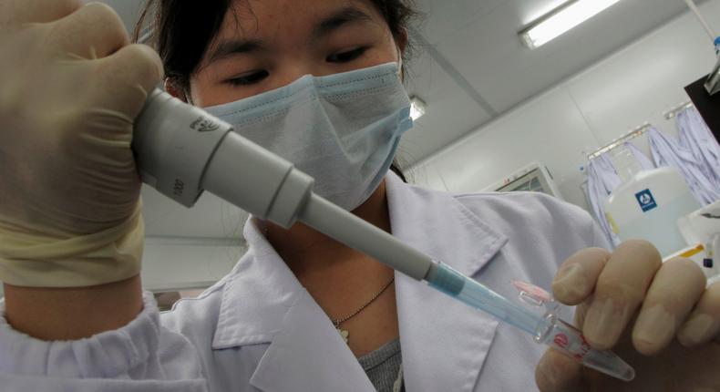 FILE PHOTO: A researcher inserts a sample into a receptacle inside the