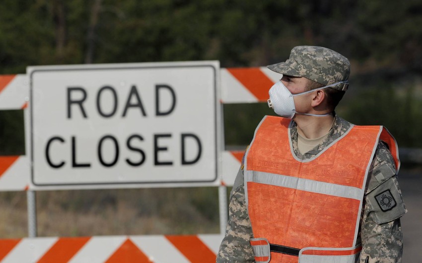 Pripadnik Nacionalne garde Novog Meksika nosi masku na putu kod Los Alamosa, zatvorenog zbog požara