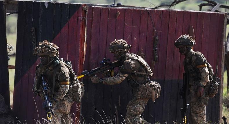 Soldiers take up position as they take part in a simulated military exercise