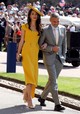 2018 - Harry herceg és Meghan Markle királyi esküvője alkalmából Amal Stella McCartney brit tervezőhöz fordult egy testre szabott mézsárga selyem midi ruháért. A megjelenés teljessé tétele érdekében arany magas sarkút és egy egyedi kalapot viselt Stephen Jones Millinery-től, amely tökéletesen passzolt a ruhájához.
