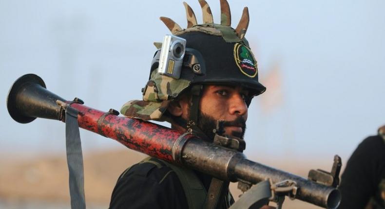 A Shiite fighter from the Hashed al-Shaabi (Popular Mobilisation) patrols in the village of Ayn Nasir, south of Mosul, on October 29, 2016, after it was recaptured from IS group jihadists