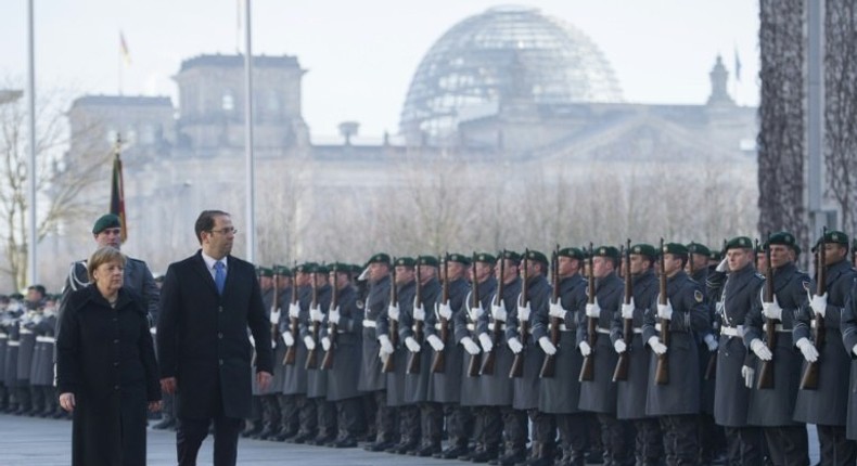 German Chancellor Angela Merkel and Tunisian Prime Minister Youssef Chahed review troops at the Chancellery in Berlin on February 14, 2017