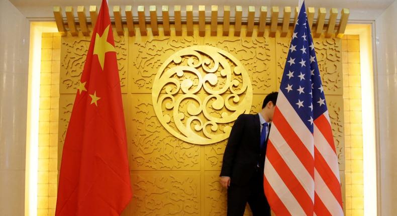 A staff member sets up Chinese and US flags for a meeting in Beijing, China.Jason Lee/Reuters