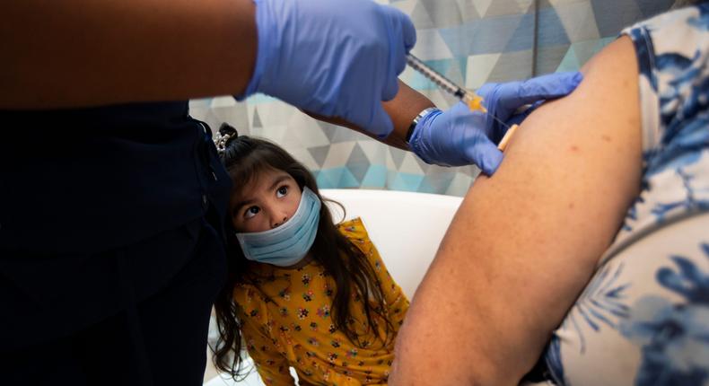 Monserat Ramos, 3, keeps a close eye on the needle as her grandparents get vaccinated in Los Angeles, California, on March 5, 2021.
