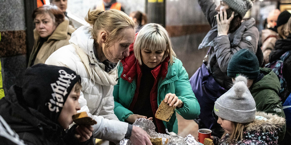 Wolontariusz rozdaje jedzenie uchodźcom na dworcu kolejowym we Lwowie. 13 marca 2022 r. 