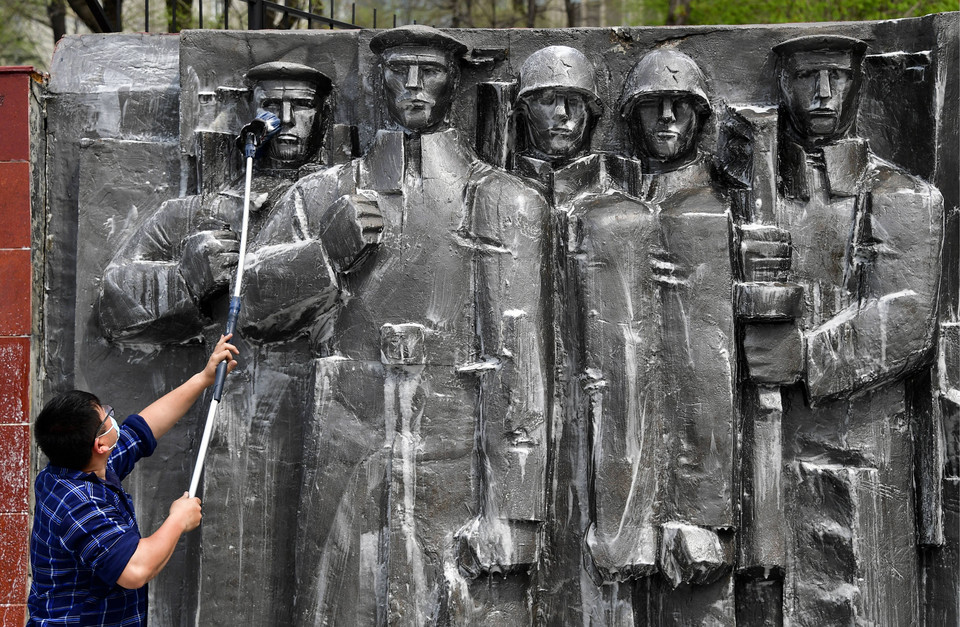 Pracownik czyszczący Mur Pamięci Bohaterów Władywostoku