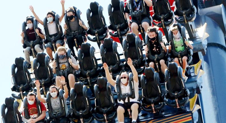 Patrons of Busch Gardens Tampa Bay enjoy the 200-foot dive on the SheiKra roller coaster, Thursday, June 11, 2020, in Tampa. The park, owned and operated by SeaWorld Entertainment, has reopened to the public for the first time in almost 3 months after closing on March 16 because of the coronavirus pandemic. (Douglas R. Clifford/Tampa Bay Times via AP)