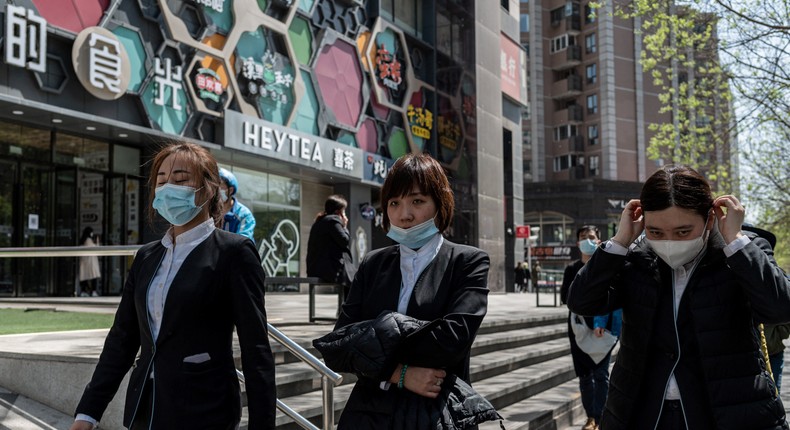 Office workers walk along a street during lunch time in Beijing
