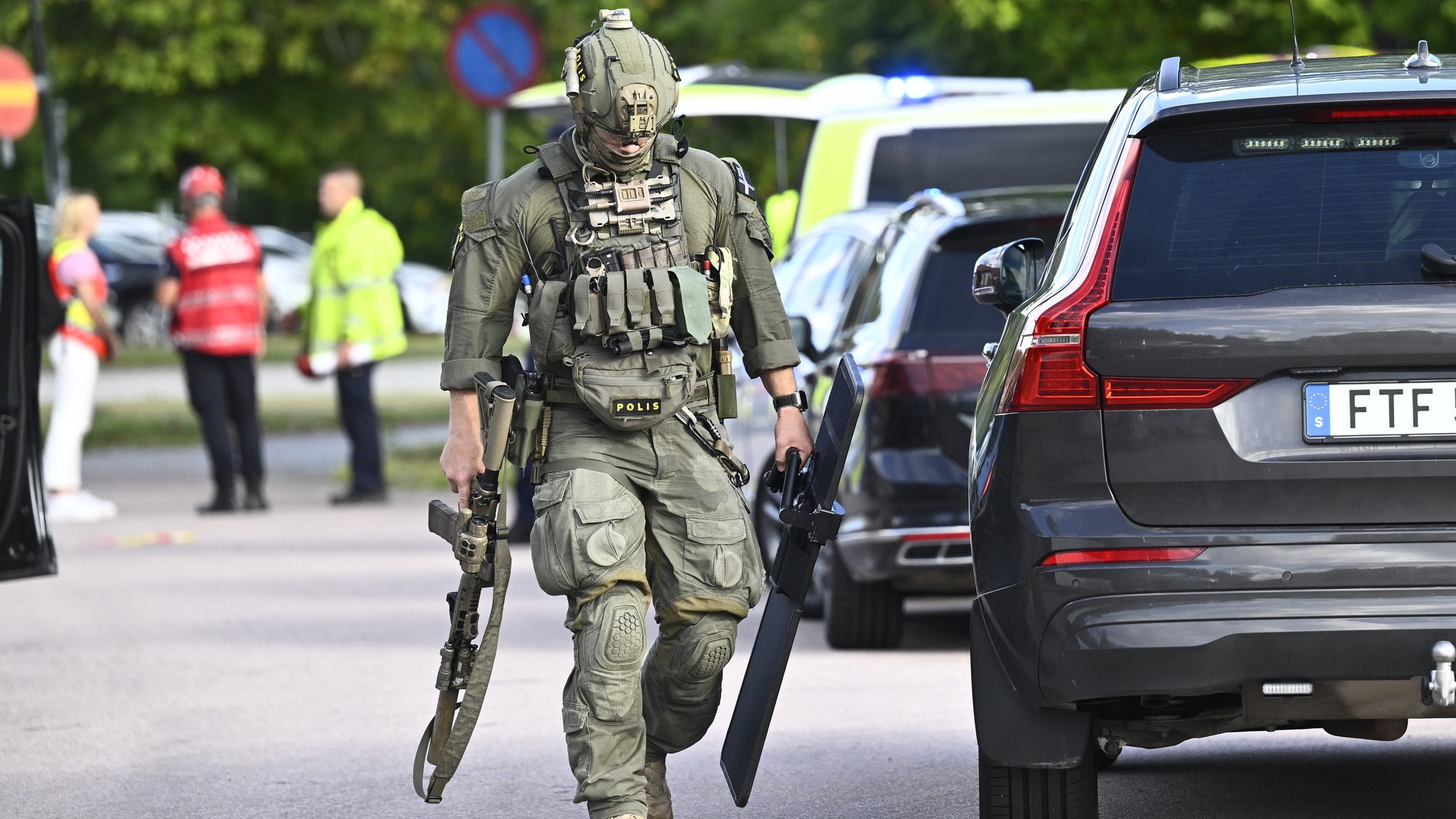 Ozbrojení policajti a záchranári zasahujú pred školou Brinellskolan.