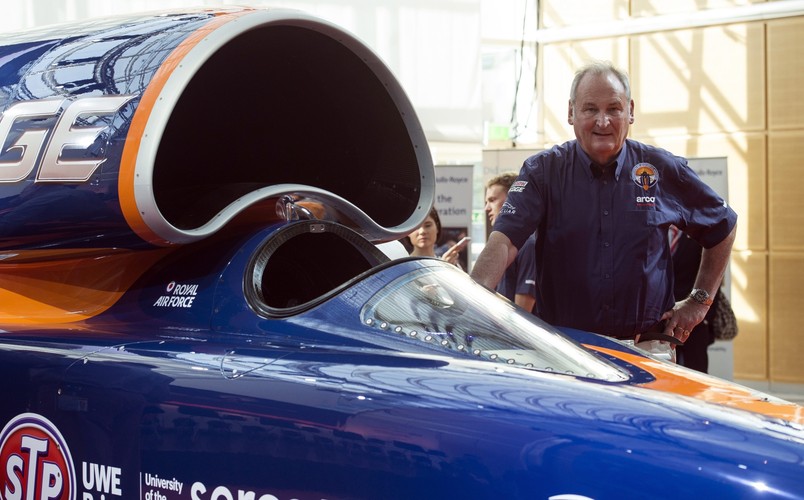 Bloodhound SSC to brytyjski naddźwiękowy pojazd lądowy, który w 2016 r. ma ustanowić światowy rekord prędkości pojazdów naziemnych. Badania nad projektem i jego budowa trwają od ośmiu lat z udziałem ponad 350 firm i uniwersytetów. <br>Na zdjęciu Richard Noble, dyrektor projektu Bloodhound stoi obok samochodu Bloodhound SSC. <br><br>fot. EPA / WILL OLIVER