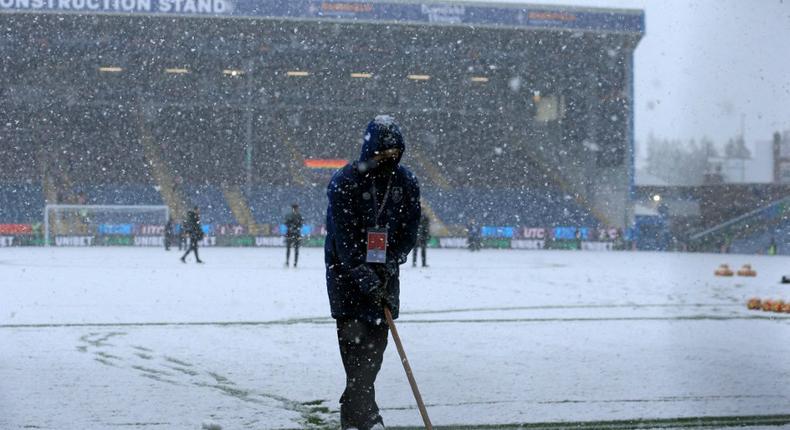 Groundstaff clear snow at Burnley's Turf Moor ground Creator: Lindsey Parnaby