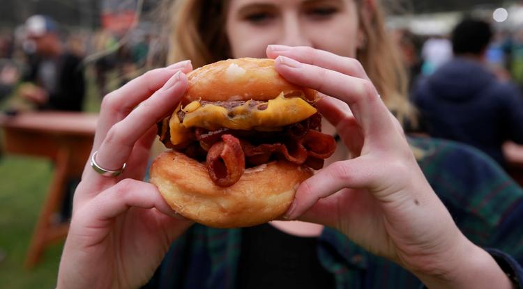 Hamburgert fogyasztó nő egy San Francisco-i zenei fesztiválon
