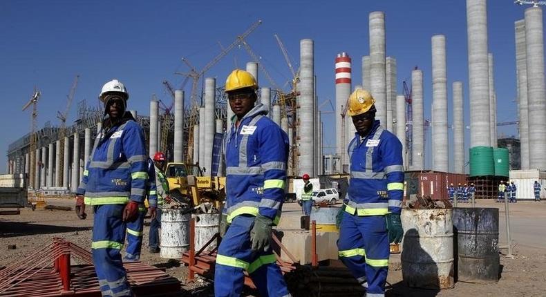 Workers are seen in front the construction site of Eskom's Medupi power station, a new dry-cooled coal fired power station, in Limpopo province, June 8, 2012. 