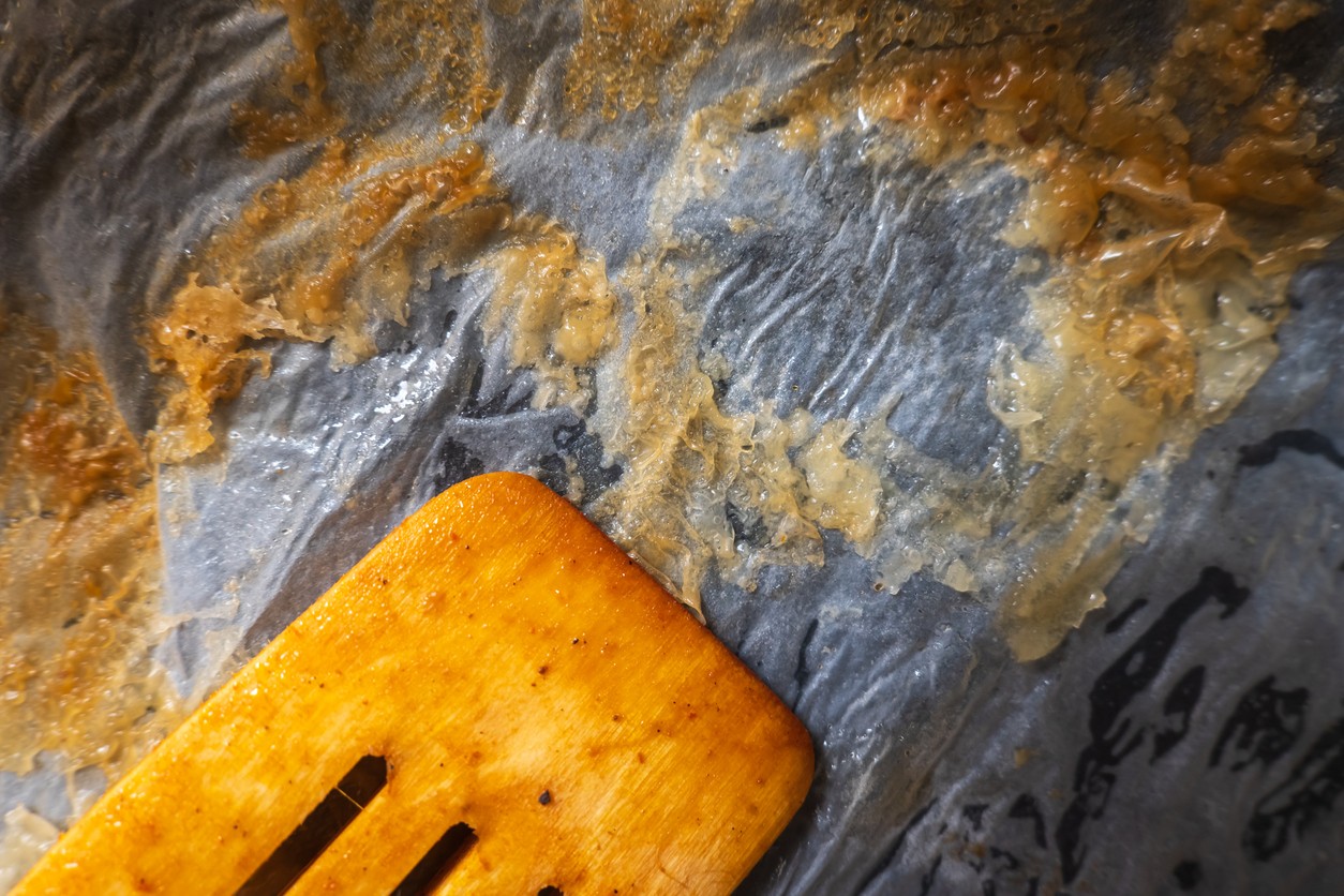 Použitý a zhnednutý papier na pečenie po vybratí z rúry. Silno pripálený, poškodený alebo mastnotou nasiaknutý papier je vhodné pred ďalším pečením vymeniť za nový.
