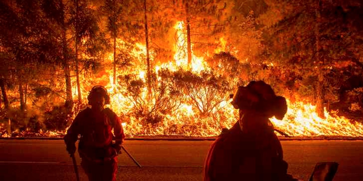 Firefighters battling the King Fire watch as a backfire burns along Highway 50 in Fresh Pond, California.