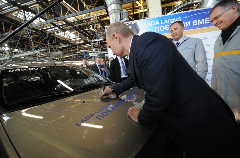 Dyrektor operacyjny Renault Carlos Tavares (po prawej) uśmiecha się, podczas gdy ówczesny premier Rosji Władimir Putin składa autograf na nowym samochodzie modelu Łada Largus, 4 kwietnia 2012 r.