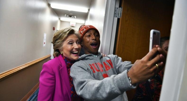 Hillary Clinton poses with singer Pharrell Williams for a selfie backstage before a campaign rally in Raleigh, North Carolina