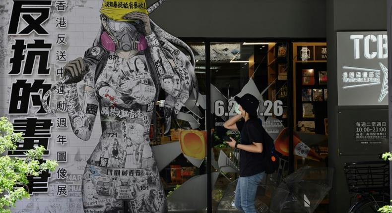 A woman in Taipei walks past a billboard promoting democracy for Hong Kong