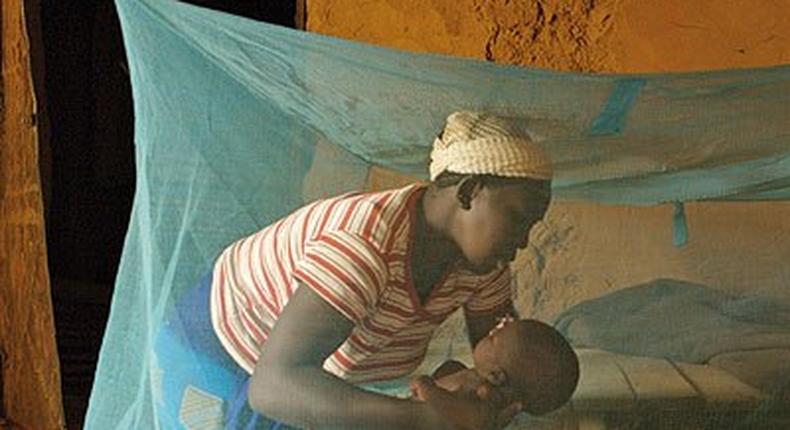 Mother and child inside a mosquito net