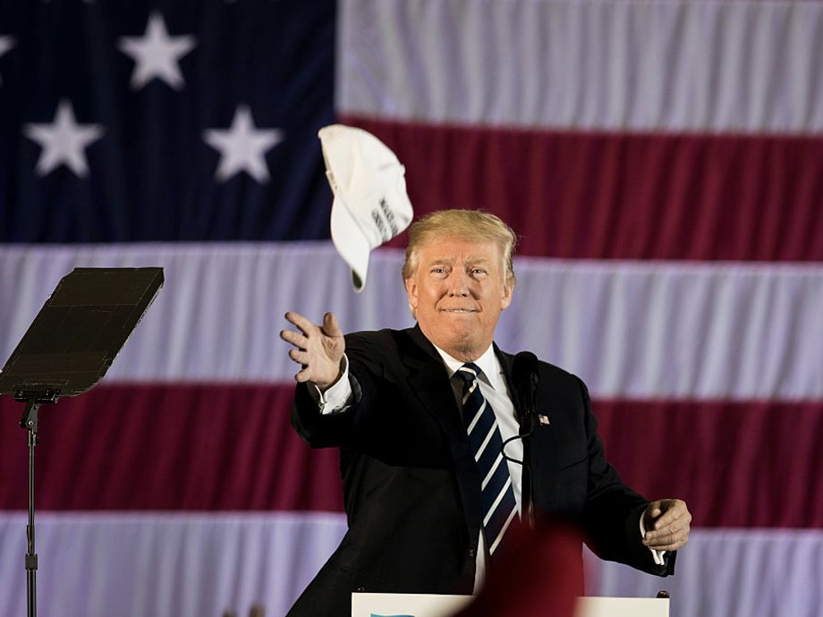 Trump throws his campaign hat into the crowd at a campaign speech.