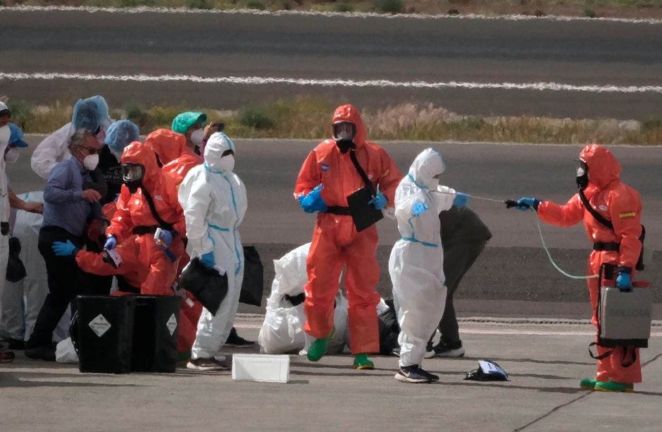 Španske vlasti dezinfikuju putnike pre ulaska avion nakon iskrcavanja sa kruzera Hondijus na aerodromu na Tenerifima 10. maja