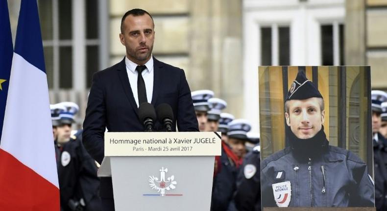 Etienne Cardiles -- stands beside a portrait of his slain partner Xavier Jugele -- during a ceremony to honour the policeman who was killed by a jihadist gunman in April 2017