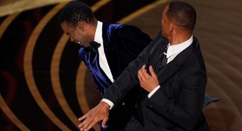Will Smith, right, hits presenter Chris Rock on stage at the Oscars on Sunday, March 27, 2022, at the Dolby Theatre in Los Angeles.