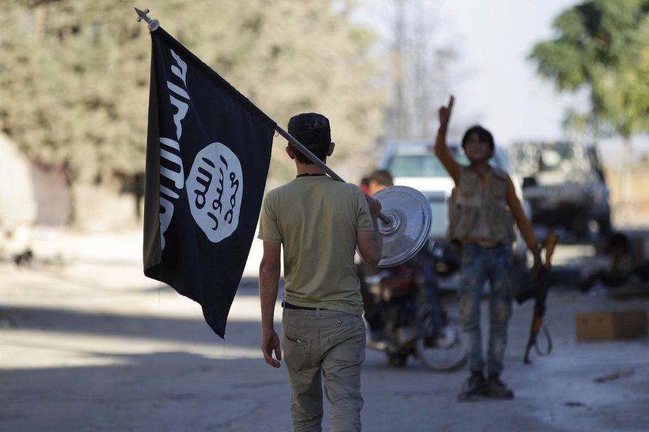 A rebel fighter takes away a flag that belonged to Islamic State militants in Akhtarin village in northern Aleppo Governorate, Syria, October 7, 2016.