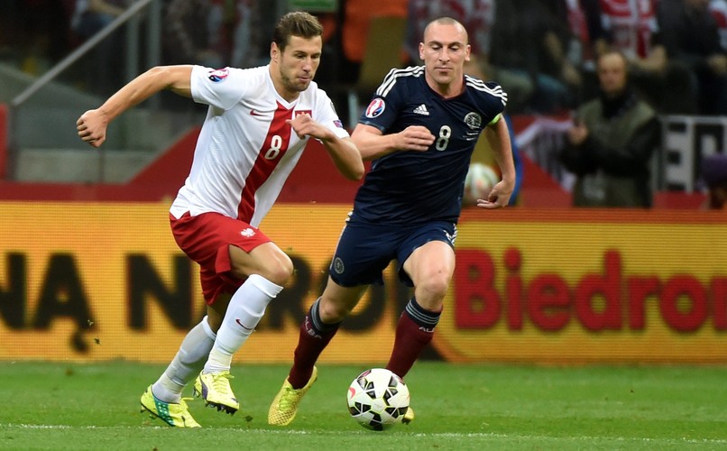 Polak Arkadiusz Milik (L) fetuje z Arturem Jędrzejczykiem (P) strzelenie bramki drużynie Szkocji na 2-2 podczas meczu eliminacyjnego piłkarskich mistrzostw Europy